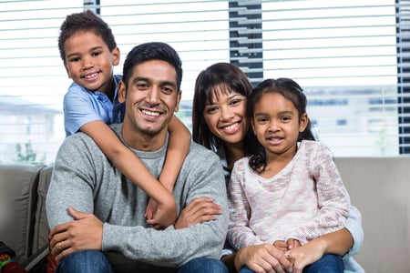 Smiling family on the sofa posing for the camera