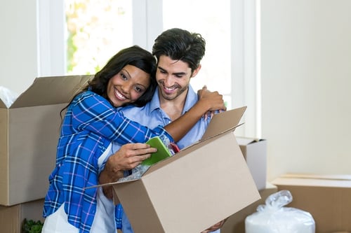 Woman Hugging Man While Packing for Their New Home